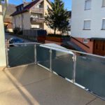 Balkongeländer mit schwarzen Scheiben und Edelstahl Rohren