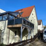 Anbaubalkon aus Stahl mit schwarzen Scheiben und Balkongeländer