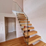 Eine Treppe eingelassen in die Wand mit Holz stufen und Glasgeländer. Design