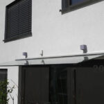 Vordach aus Glas, Ganzglassystem in Profilschiene eingesetzt an der Hauswand